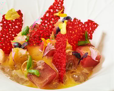 Vibrant fine dining dish with red crisps and edible flowers.