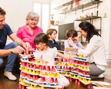 Family creating a structure from colorful silicone cones and wooden tables in the room