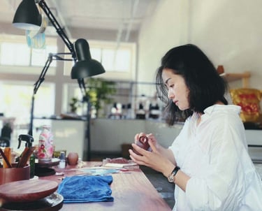 Artisan Kuai Yunhan examining a teapot