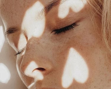 une femme détendue avec des lumières en forme de coeur sur son visage au soleil