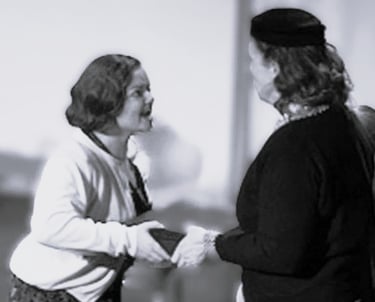 Two women, one young, one older, tussle over a box, each trying gain possession of it.