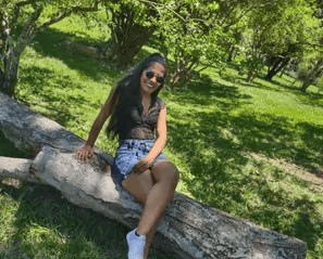 Mulher sorridente sentada em um tronco de árvore