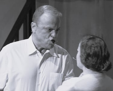 A very angry man is yelling a young woman.