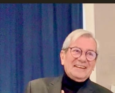a man in a suit and glasses smiling
