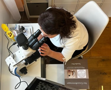 a woman in a white shirt and black pants sitting at a table with a laptop