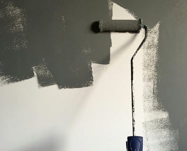Ouvrir qualifié : rouleau de peinture gris sur un mur blanc