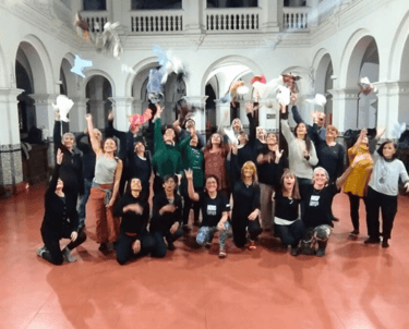 Estudiantes de Noelia sonriendo y lanzando pañuelos al aire al finalizar la clase