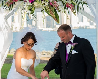 couple pouring sand for sand ceremony, wedding at Harbor Island park overlooking San Diego skyline