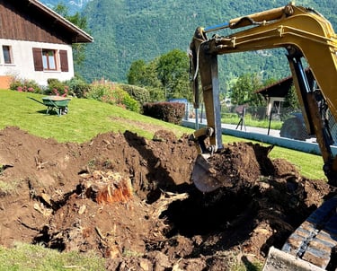 Pelle mécanique en action lors du dessouchage d’un arbre, chantier de terrassement au bout du lac d’