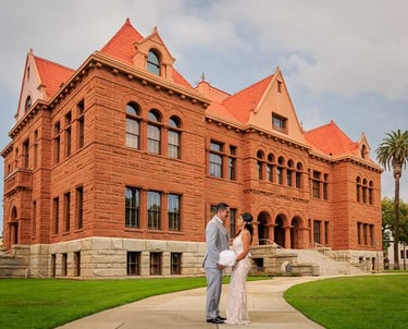 A bride and groom standing in front of the Old Orange County Courthouse
