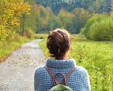 Femme de dos se promenant dans la nature.