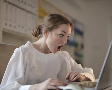 mulher usando laptop com expressao de surpresa