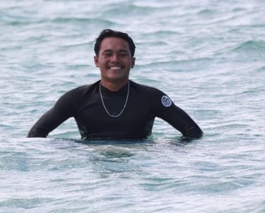 Romi smiling warmly at Paradise Surf School Lombok, embodying the friendly spirit of surfing and instruction.