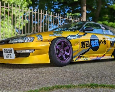 a yellow car with a large number of stickers on it