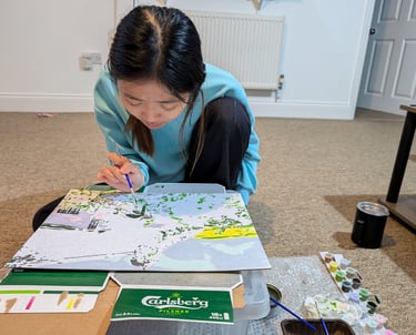 lady in blue dress sitting and painting carefully