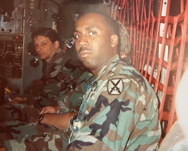Lee A Jones in camouflage gear sitting in a military transport helicopter