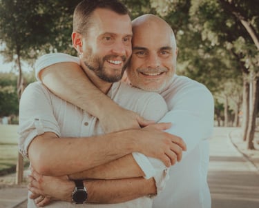 "Pareja gay abrazándose en el Gay Pride, celebrando su amor y apoyo a la comunidad LGBTQ+."