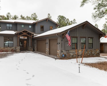 custom home with large garage and snowy driveway