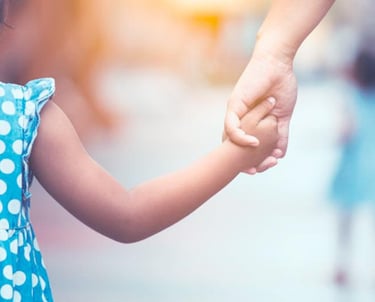 a young girl holding hands with her father