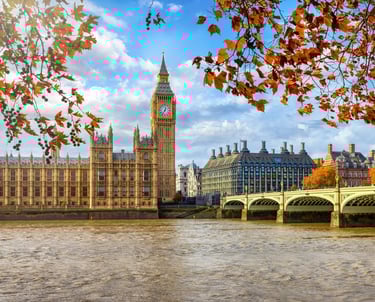 a bridge over a river with a clock tower in the background