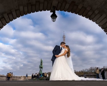 "Pareja heterosexual casada besándose bajo la Torre Eiffel en París, celebrando su amor y unión."