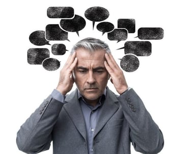 un homme e tenant la tete avec des pensées et un dialogue interieur negatif sous forme de bulle noir