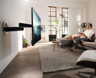 A couple enjoying a movie in a luxury London living room featuring a custom motorised TV mount