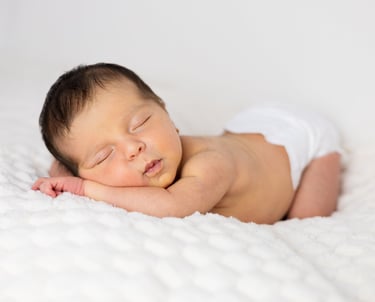 Sessió de fotos newborn a Girona amb una bebè recent nascuda dormint en estudi fotogràfic