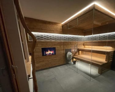 Moderne Innensauna mit Eckverglasung, ausgestattet mit rustikaler Holzverkleidung und indirekter LED-Deckenbeleuchtung