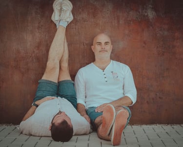 "Pareja gay de novios sentados en verano, disfrutando del ambiente del Pride y celebrando su amor."