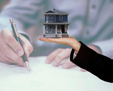 a person holding a house model of a house