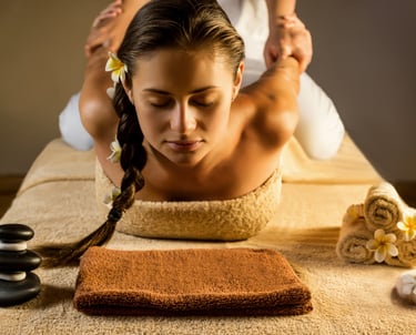 a long haired lady relaxes, eyes closed while the masseuse stretches and puls her 2 arms to her back