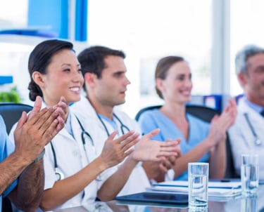 a group of doctors and nurses in a conference room