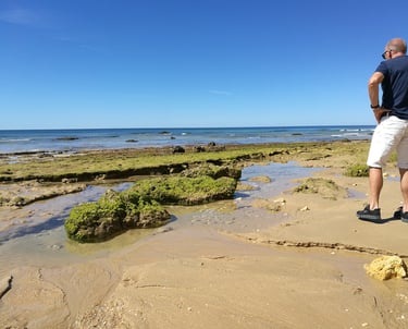 Man die geniet van de prachtige kustlijn van Praia do Barranco
