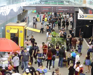 Pessoal caminhando no evento e outros pedindo comida no food truck