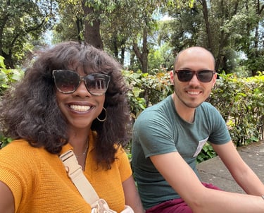 a man and woman sitting on a bench in a park
