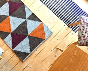 Modern handwoven kilim rug with geometric triangles in orange, burgundy and brown, adding warmth and