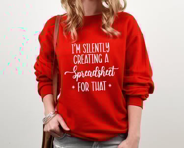 A woman in a red sweatshirt with white stylized letters reading "I'm silently creating a Spreadsheet for that"