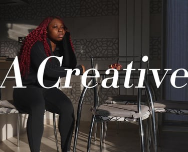 a picture of a girl with dark red hair sitting down in a video production