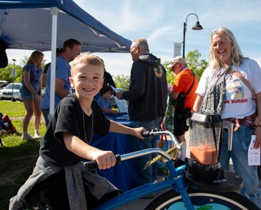 Child posing for the camera while powering our blender bike at an event!