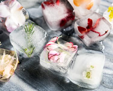 Cubes de glace fleuris, utilisés pour des rituels poétiques de dispersion symbolique des cendres.