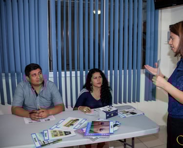 a woman standing in front of a table with a man in a blue shirt