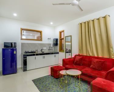 "Living room of 1 BHK apartment with sofa and TV" "Dining area inside 1 BHK apartment"