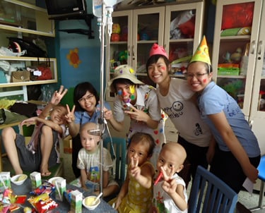 a group of people standing around a table with cake