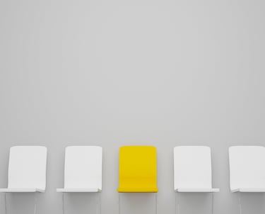 Yellow chair standing out from row of white chairs