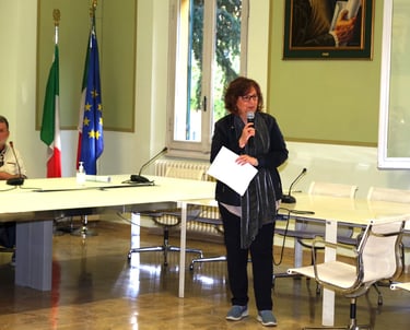 a woman standing in front of a table with a microphone