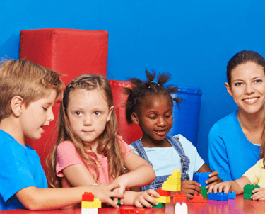 a woman and children playing with blocks on a table