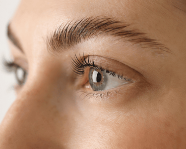 A female client in Oklahoma City showcasing the results of a lash lift and brow lamination, with her