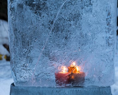 Bougie allumée figée dans la glace, symbole de mémoire et d’introspection hivernale.