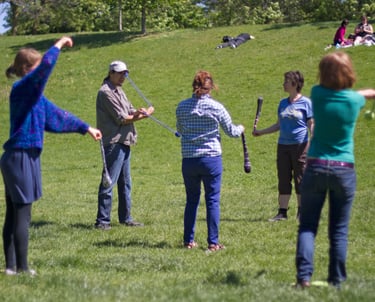 The Pyroneer teaching group Poi lesson in a park./